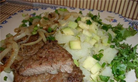 Veal steak with onions and potatoes with avocado.