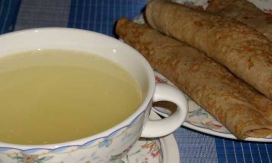 Transparent chicken broth with pancakes stuffed with porridge