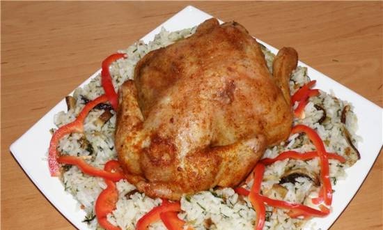 Pollo appetitoso su cuscino di riso con funghi porcini