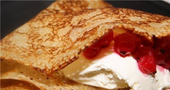 Thin milk pancakes with cream cheese and currants