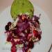 Salad of two types of cabbage with grilled onions and berry sauce on a bun made of aromatic herbs