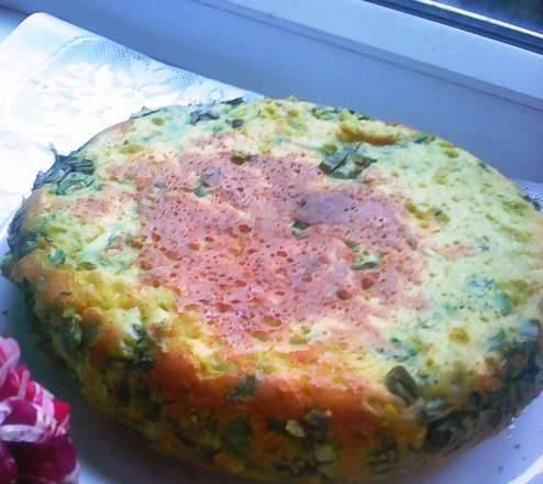 Pastel de tortilla con huevos y cebollas verdes en una olla de cocción lenta u horno