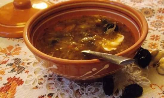 Lean cabbage soup with cabbage, beans, mushrooms and prunes under a bread lid