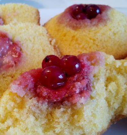 Sunny cupcakes with strawberries and red currants on corn flour