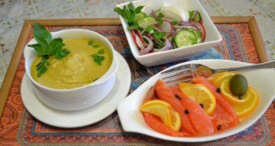 Complex lunch of vegetable puree soup with avocado, fish appetizer and vegetable salad