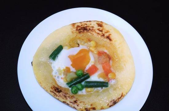 Fried eggs in zucchini with vegetables