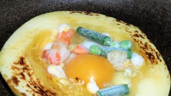 Fried eggs in zucchini with vegetables