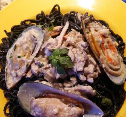 Black spaghetti with seafood with creamy mushroom sauce