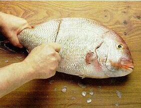 De vis staat bij ons op tafel. Vis snijden.