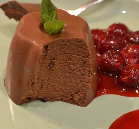 Milk and chocolate dessert with cherry syrup