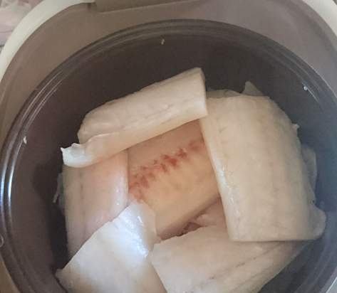 Filet de Pollock sobre un coixí de carbassó amb ceba i formatge