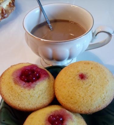 Cupcakes Sunny with strawberries and red currants on corn flour