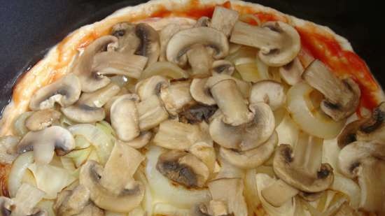 Pizza sobre una base fina de llevat amb bolets i ceba, cuita al mode 