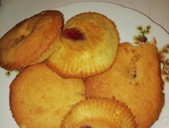 Cupcakes Sunny with strawberries and red currants on corn flour