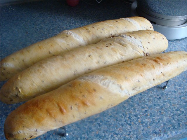 Baguettes de massa fermentada en una màquina de fer pa