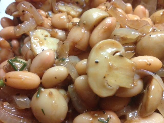 Insalata piccante con fagioli, cipolle fritte e funghi.